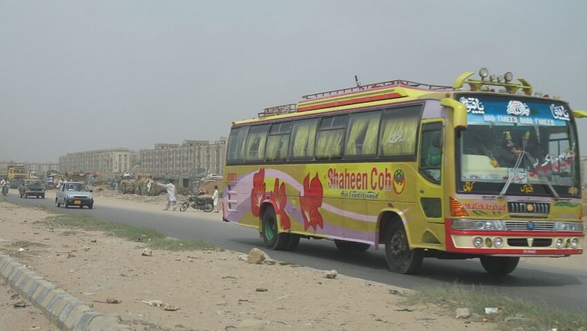 شاہراہ پر چلتی ہوئی ایک رنگ برنگی پاکستانی انٹرسٹی مسافر کوچ