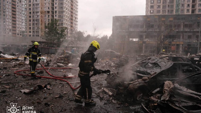 روسی میزائل حملے کے بعد کیف میں امدادی کارکن تباہ شدہ عمارتوں کے ملبے میں کام کرتے ہوئے
